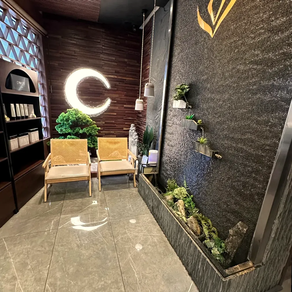 Inside Zenko Spa in Fort Lauderdale — the water wall with gold emblem beside the crescent-lit relaxation lounge